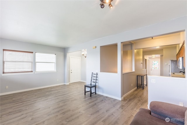 interior space with plenty of natural light, light wood-type flooring, and baseboards