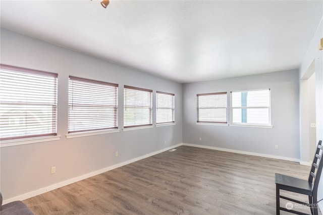 unfurnished room featuring baseboards and wood finished floors