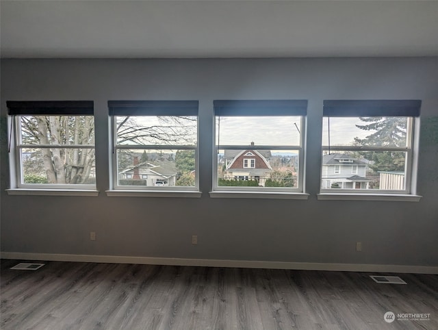 spare room with plenty of natural light, visible vents, and baseboards