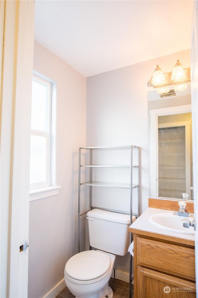 bathroom with baseboards, visible vents, vanity, and toilet