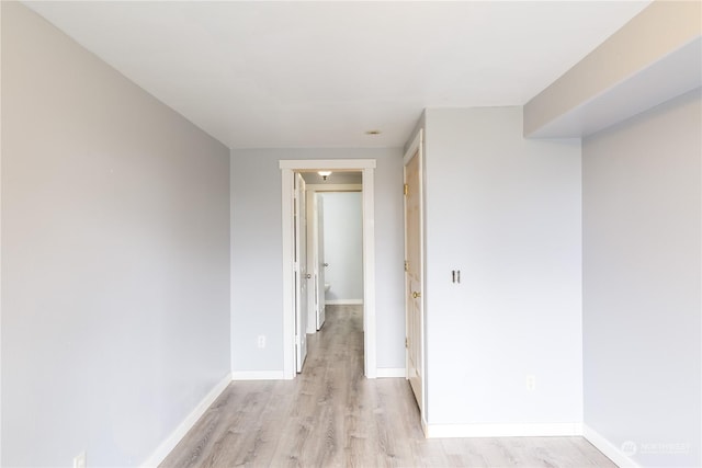 hallway with baseboards and light wood finished floors