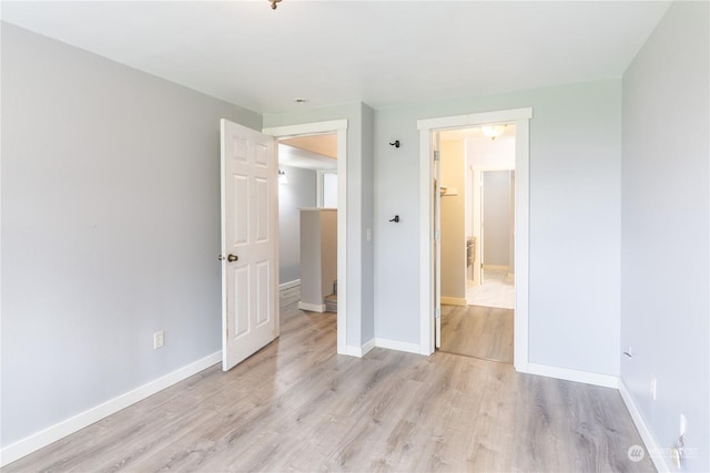 unfurnished bedroom featuring light wood-style flooring and baseboards