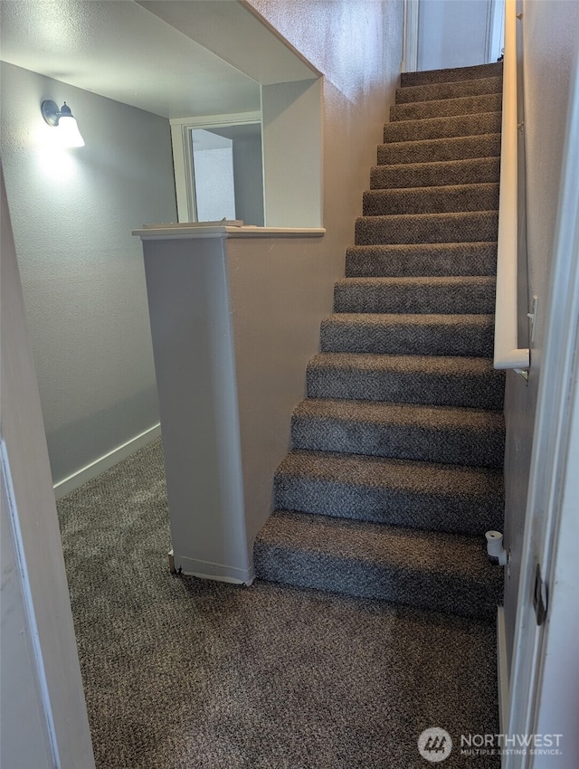 staircase featuring carpet flooring and baseboards