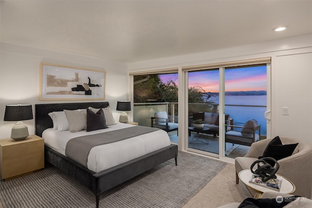 carpeted bedroom featuring a water view and access to outside