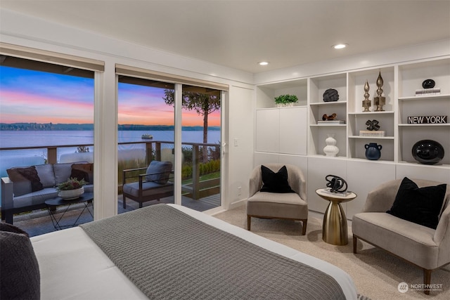 bedroom featuring a water view, carpet, and access to outside