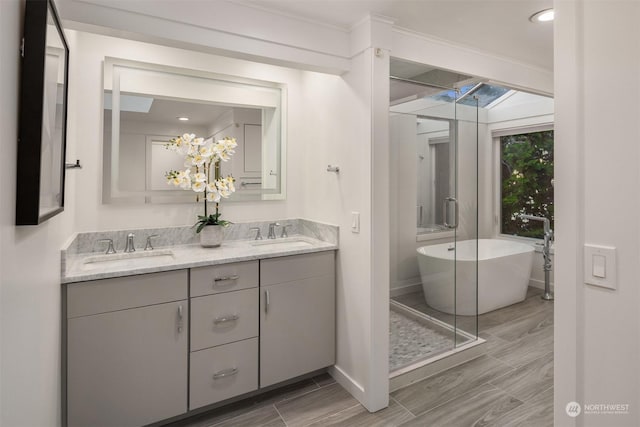 bathroom featuring ornamental molding, vanity, and a washtub