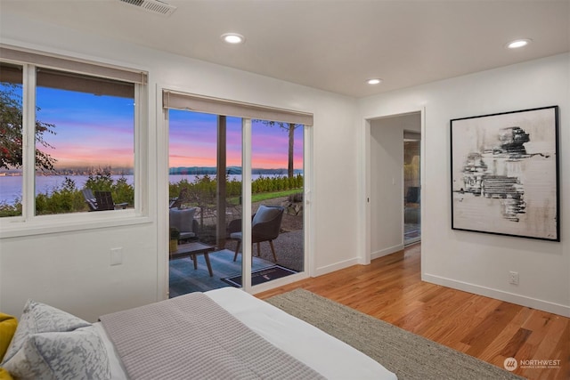 bedroom with hardwood / wood-style floors and access to exterior