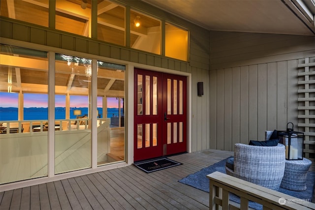 exterior entry at dusk with a deck with water view