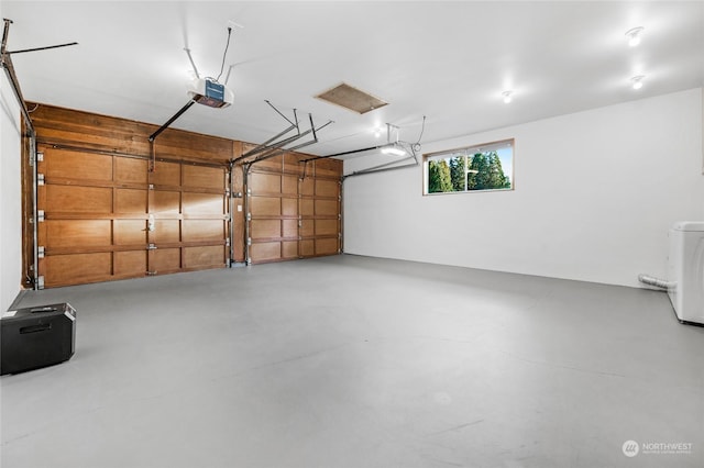 garage featuring a garage door opener and washer / dryer