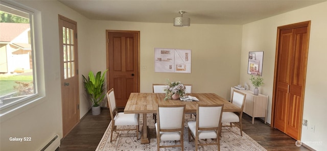 dining area with a baseboard heating unit and dark wood-type flooring