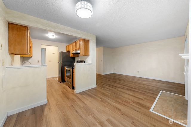 kitchen featuring electric stove, a textured ceiling, and light wood-type flooring