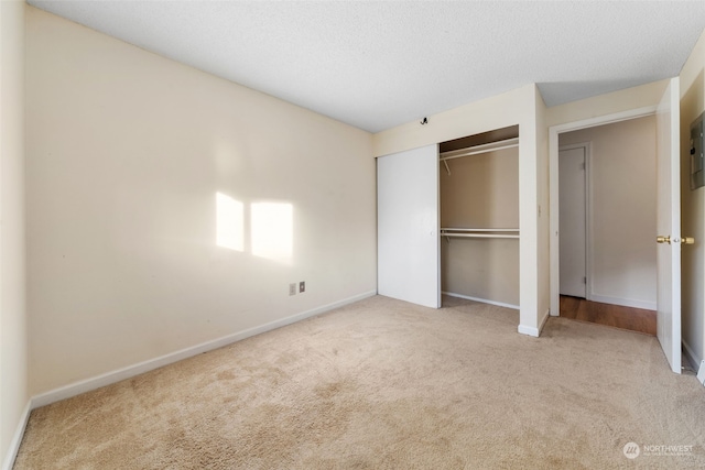 unfurnished bedroom featuring light carpet and a closet