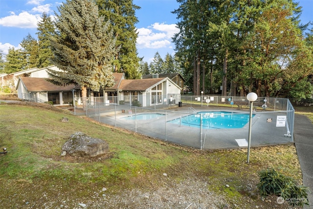 view of pool with a lawn