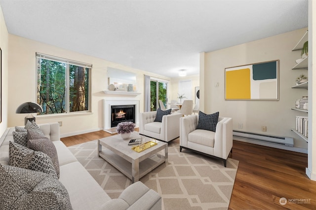 living room with a baseboard heating unit, wood-type flooring, and plenty of natural light