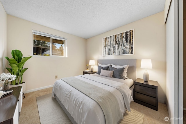 bedroom featuring light colored carpet and a textured ceiling