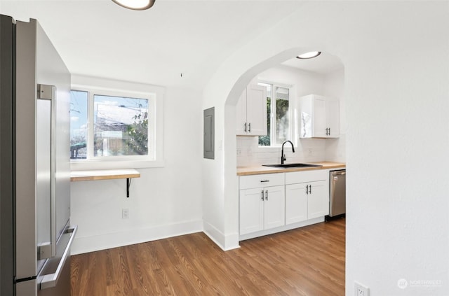 bar featuring white cabinetry, stainless steel appliances, sink, and wood-type flooring