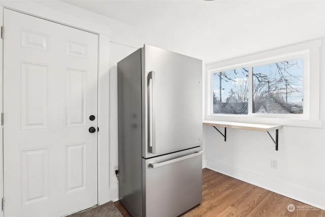 kitchen with stainless steel fridge and dark hardwood / wood-style floors