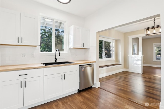 kitchen featuring pendant lighting, sink, dishwasher, white cabinetry, and wood counters