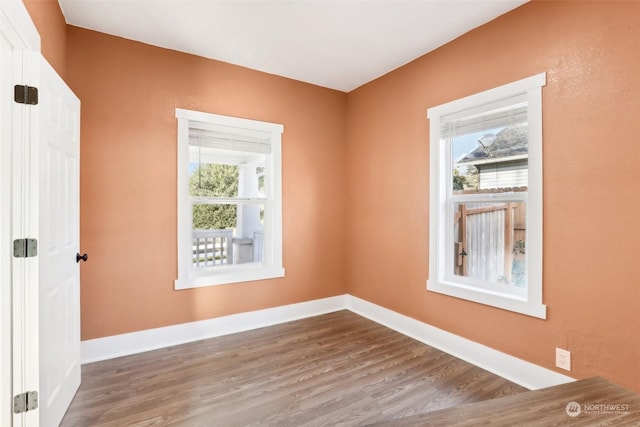 unfurnished room with wood-type flooring and a healthy amount of sunlight