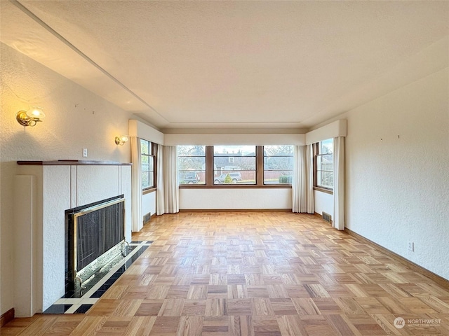 unfurnished living room with light parquet flooring and a textured ceiling