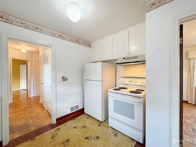 kitchen with white appliances, light parquet flooring, and white cabinets