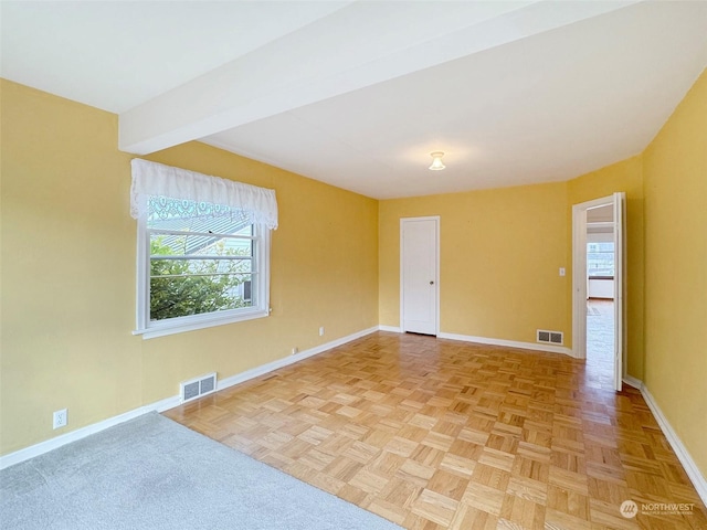 unfurnished room with beamed ceiling and light parquet flooring