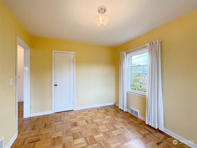 unfurnished room featuring light parquet flooring