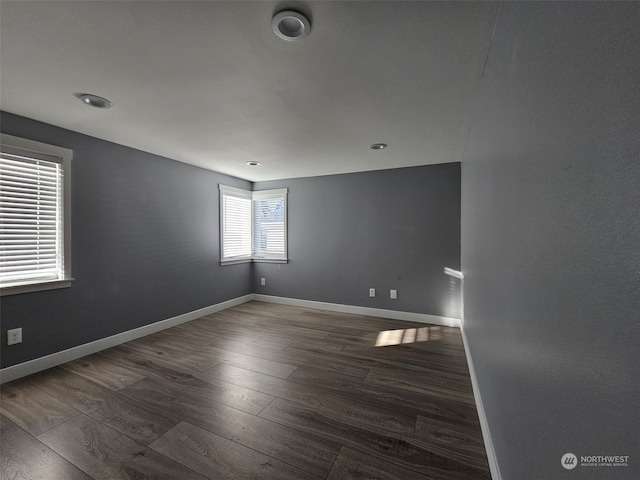 unfurnished room with dark hardwood / wood-style flooring