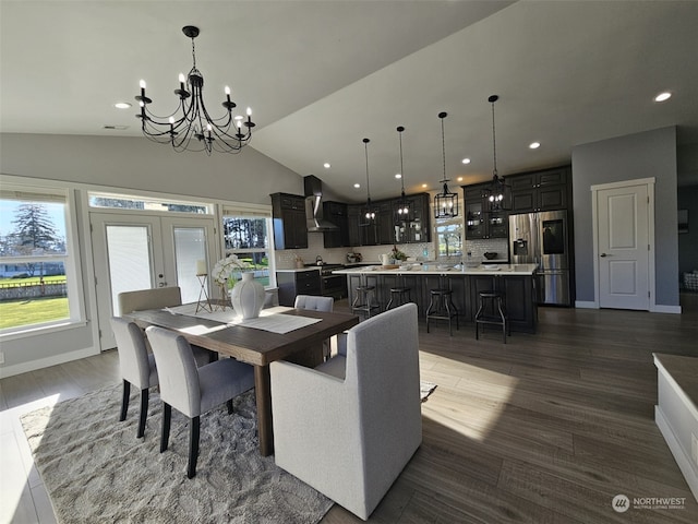 dining area featuring french doors, lofted ceiling, dark hardwood / wood-style flooring, and a chandelier