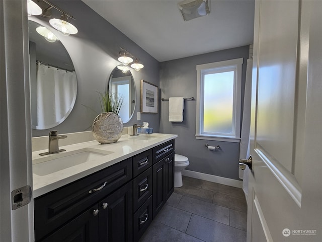 bathroom with tile patterned flooring, vanity, and toilet