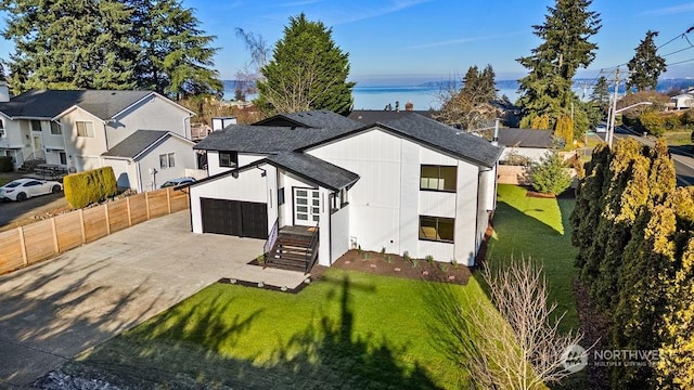 rear view of property with a garage and a lawn