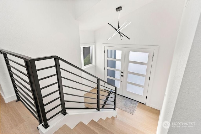 entrance foyer featuring french doors, a notable chandelier, and light wood-type flooring