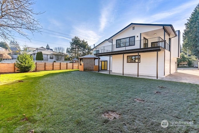 rear view of property featuring a yard and a balcony