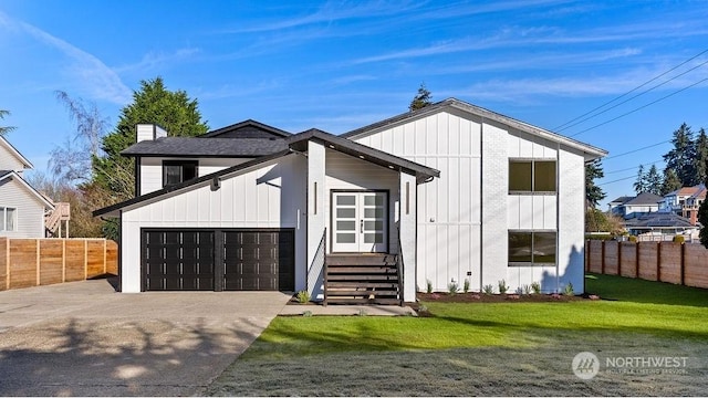 modern inspired farmhouse with a garage and a front lawn