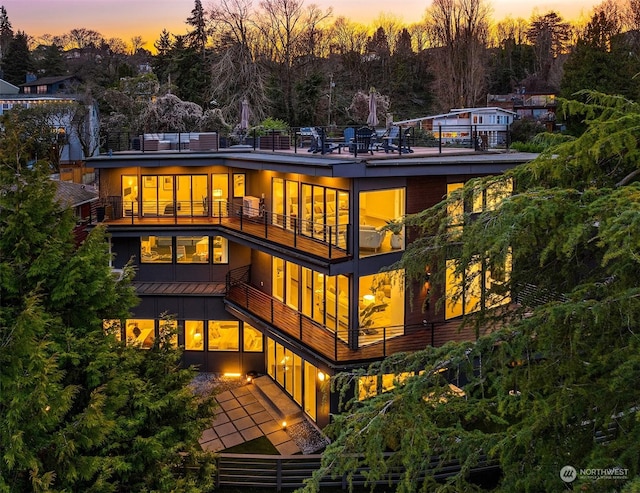 back house at dusk with a balcony