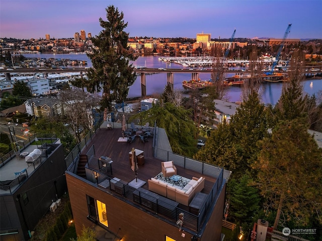 aerial view at dusk featuring a water view