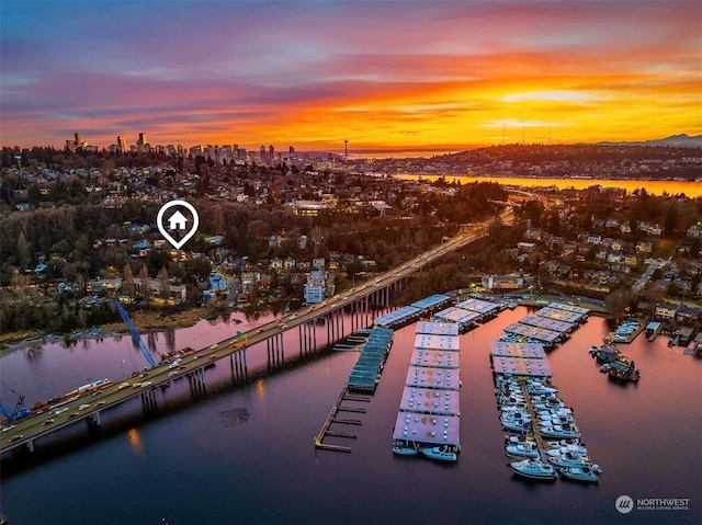 aerial view at dusk featuring a water view