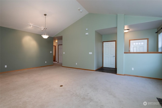 carpeted spare room with high vaulted ceiling