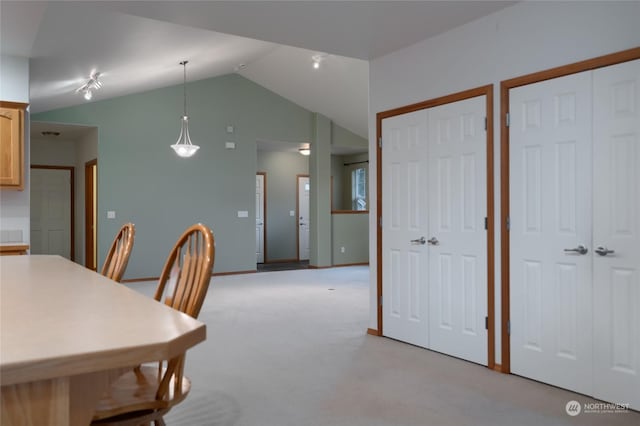 carpeted dining area with lofted ceiling