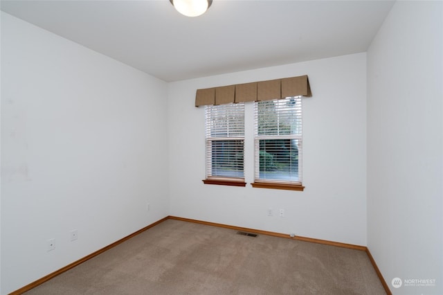 unfurnished room featuring light carpet