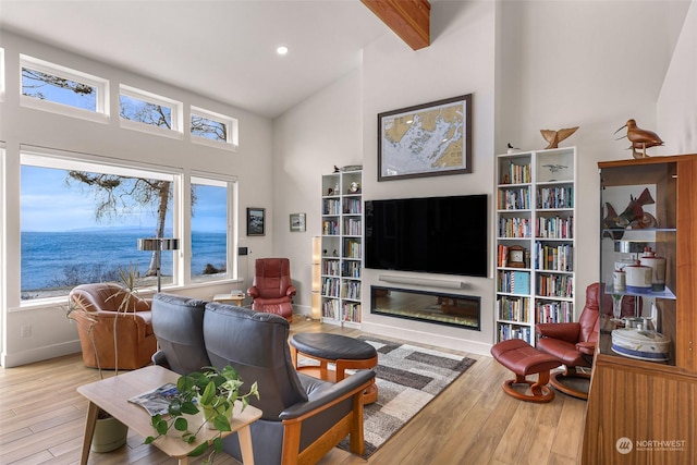 living room with beamed ceiling, a water view, high vaulted ceiling, and light wood-type flooring