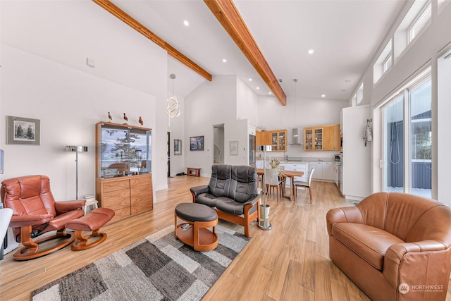 living room with beam ceiling, high vaulted ceiling, and light hardwood / wood-style flooring