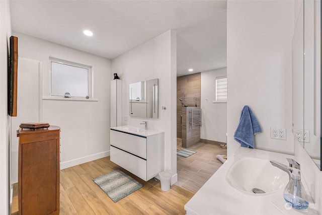 bathroom with vanity, wood-type flooring, and tiled shower