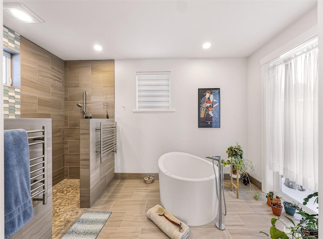 bathroom featuring shower with separate bathtub