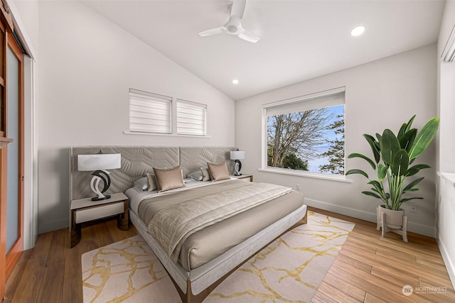 bedroom with multiple windows, hardwood / wood-style floors, and vaulted ceiling