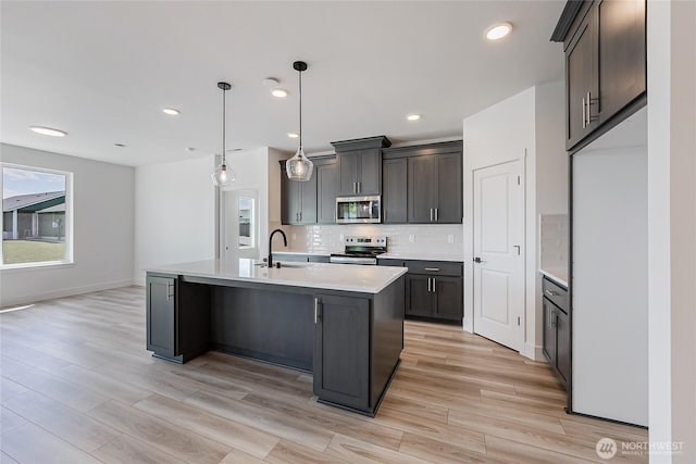402 Pagget Ave, Winlock, WA 98596 - kitchen with appliances with stainless steel finishes, a sink, tasteful backsplash, light countertops, and light wood-style flooring