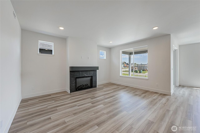 402 Pagget Ave, Winlock, WA 98596 - unfurnished living room featuring a tile fireplace, light wood-style flooring, recessed lighting, and baseboards