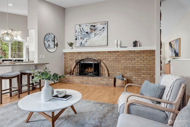 living room featuring a fireplace, wood-type flooring, and sink