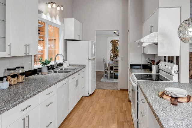 kitchen with white cabinetry, sink, white appliances, and light hardwood / wood-style flooring