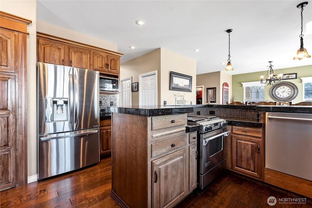 kitchen featuring hanging light fixtures, dark wood-type flooring, and appliances with stainless steel finishes